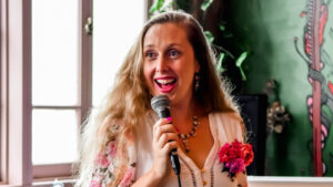 Are you asking for what you want? Emma Lovell smiling with a microphone at an event